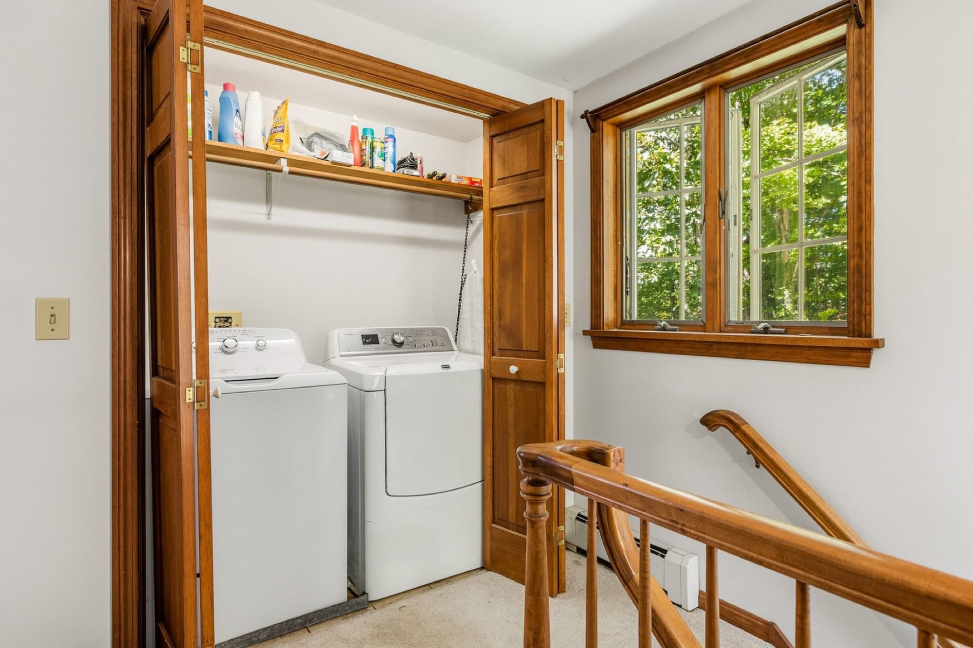 The second-floor laundry closet at the top of the stairs