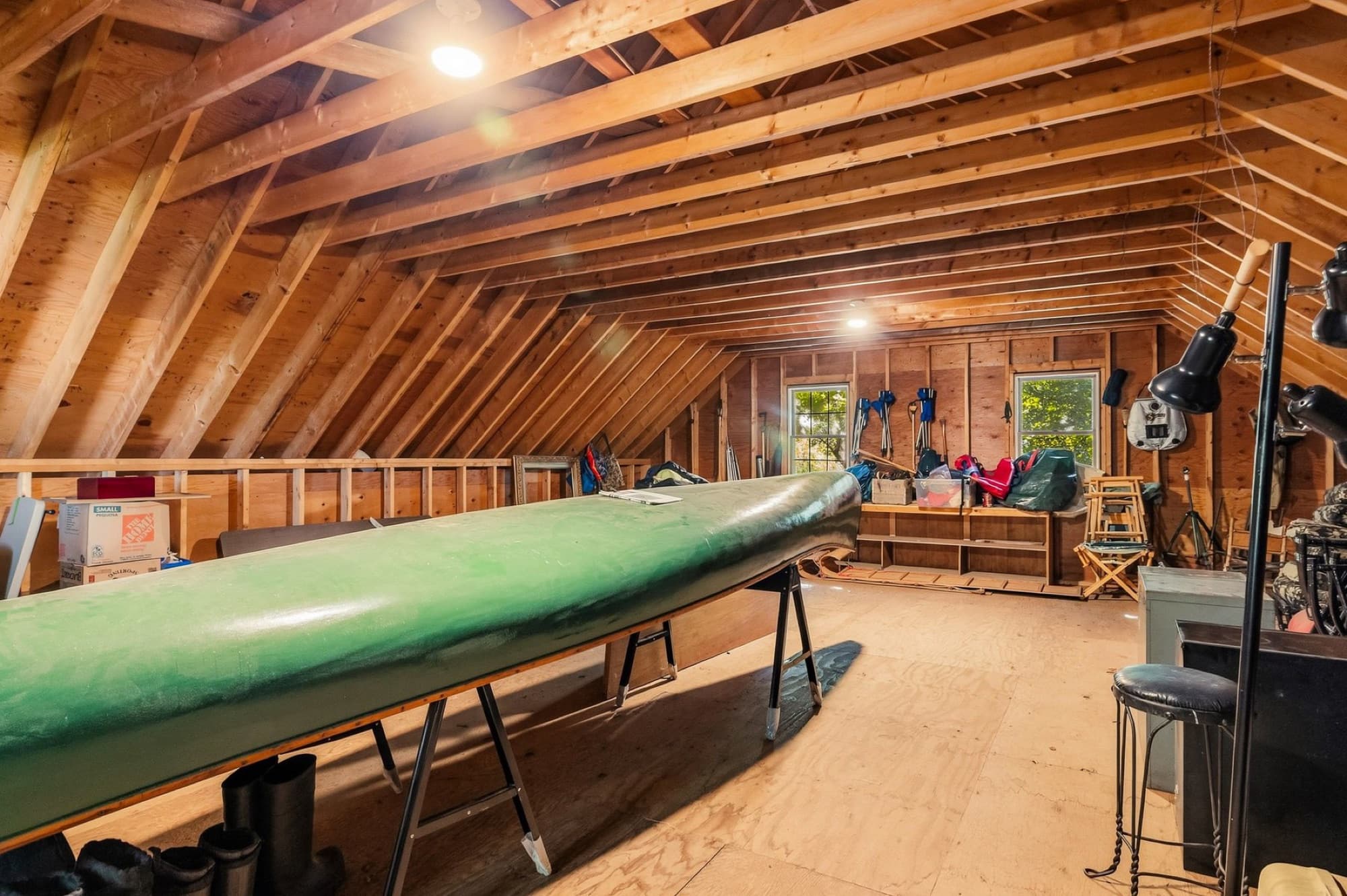 The unfinished loft above the garage, open to the rafters, with a canoe